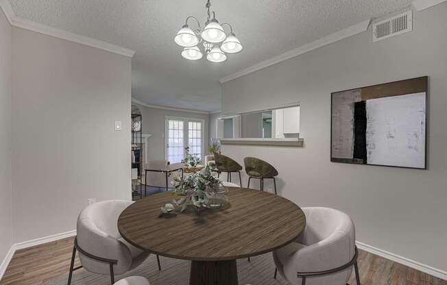A dining room with a round table and chairs.