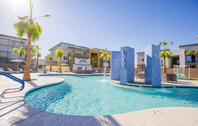 a swimming pool with palm trees and apartments in the background