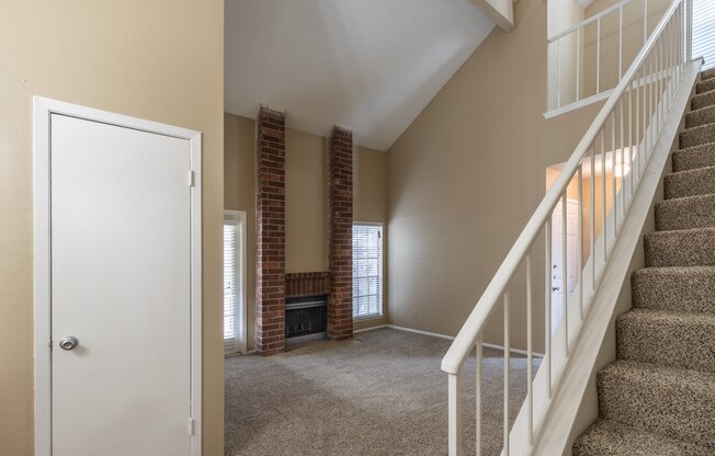 A room with a staircase and a fireplace.