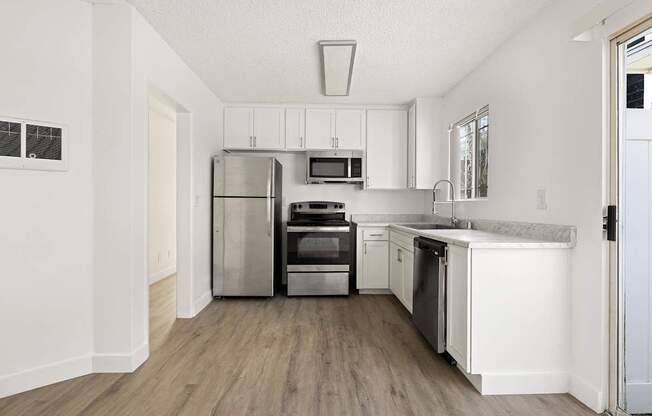 A modern kitchen with stainless steel appliances and white cabinets.