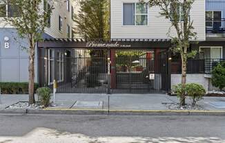 the entrance to property building with a black gate and property signage in white lettering on the front of it at Promenade at the Park Apartment Homes, Seattle, Washington 98125