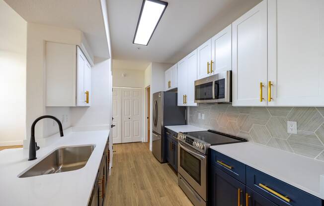 a kitchen with white countertops and blue cabinets