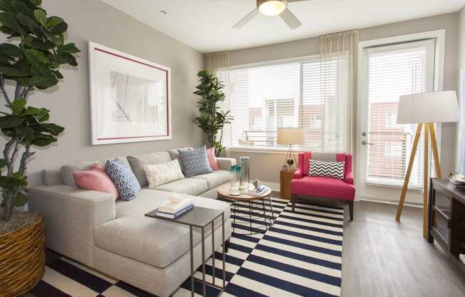 a living room with a large window and a ceiling fan