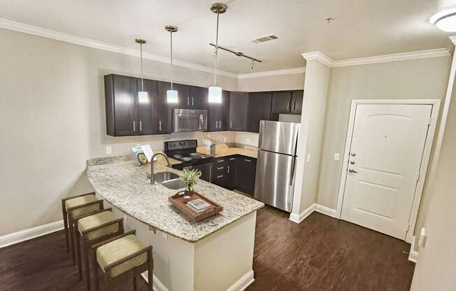 A kitchen with a granite countertop and stainless steel appliances.