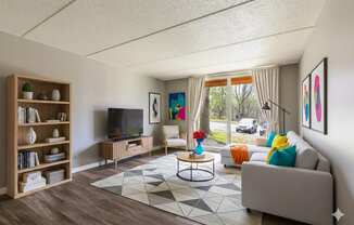 A living room with a grey couch, a coffee table, a television, and a bookshelf.