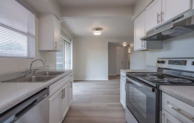 a kitchen with white cabinets and a stainless steel stove