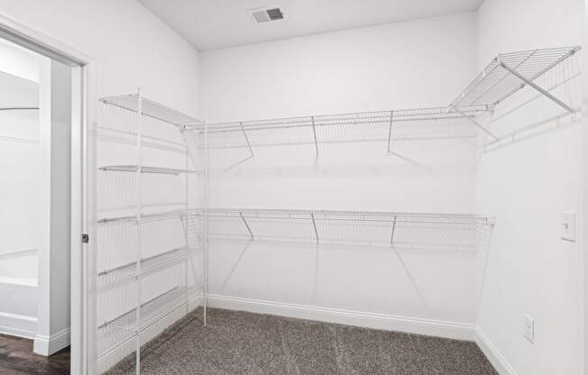 the closet in a bedroom of a home with white walls and white closets with