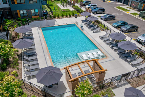 a swimming pool with chairs and umbrellas at a hotel