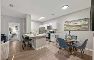 an open kitchen and dining area with a table and chairs and a living room