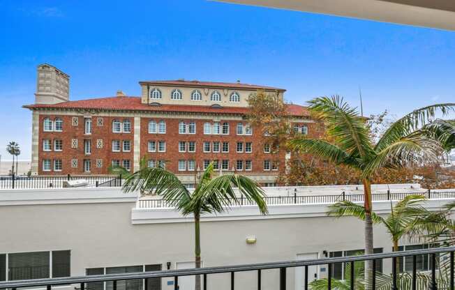 a view of a building from a balcony with palm trees