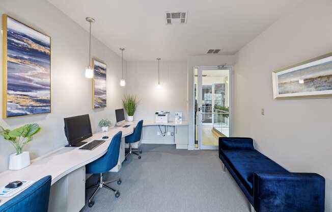 Resident business center with workstations and two blue chairs