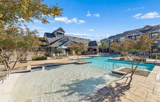 A large swimming pool surrounded by a wooden deck and trees.
