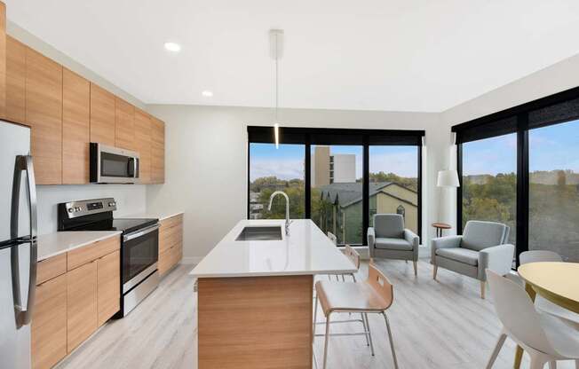 A modern kitchen with a large island and a view of the outdoors.