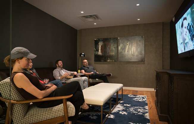 a group of people sitting in a room watching a movie