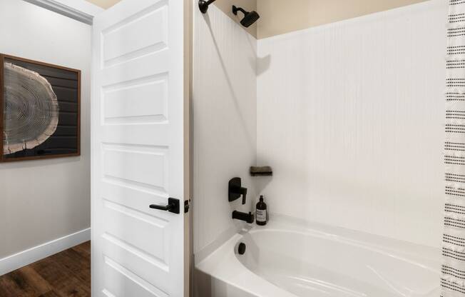 a bathroom with a bath tub and a white door