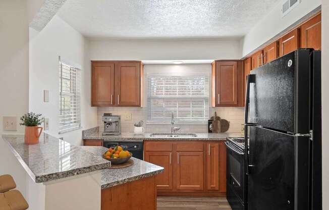 a kitchen with black appliances and granite counter tops