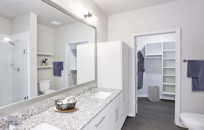 Granite countertops and framed mirrors in bathrooms