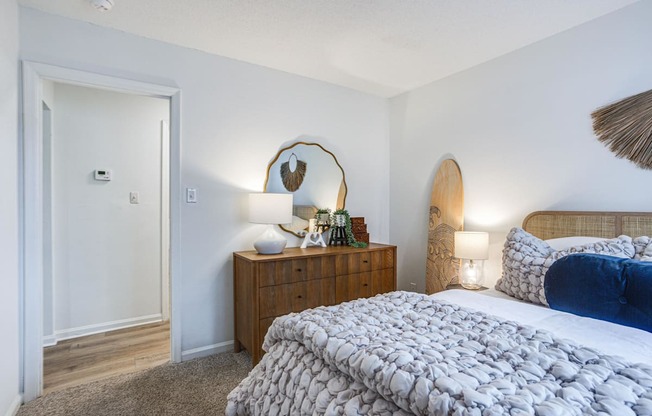 a bedroom with a bed and a dresser with a mirror