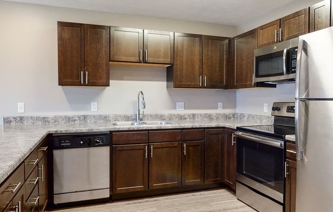Renovated kitchen with granite counters and new appliances at Northridge Heights Apartments