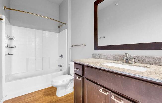 A bathroom with a white toilet and a marble countertop.