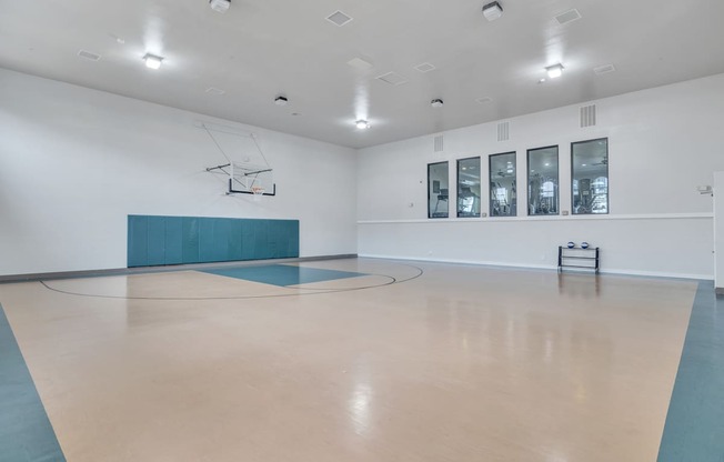 the multipurpose room has a basketball court and a large window