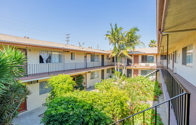 the courtyard of a building with balconies and trees