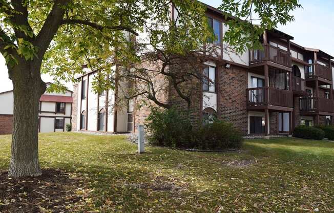 the courtyard of an apartment building with mature shade trees at Seville Apartments, Michigan