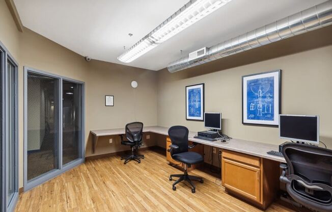 an office with two desks and two computer monitors