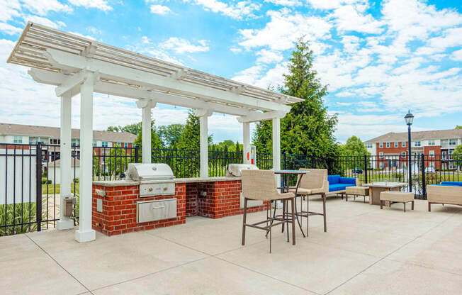 a patio with a barbecue grill and a pergola