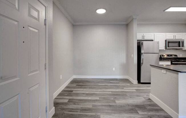 A kitchen with a refrigerator, microwave, and oven.