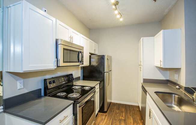 A kitchen with white cabinets and black appliances.