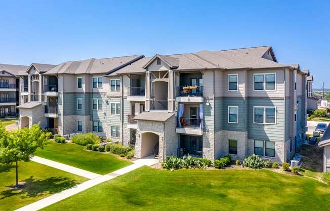 an apartment building with green lawns and a blue sky