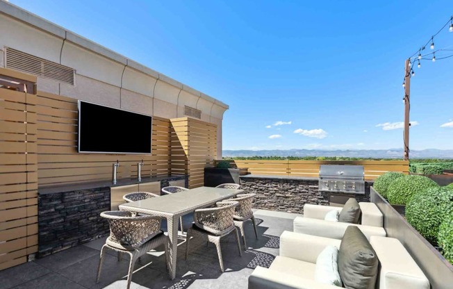 a patio with furniture and a grill on the side of a building