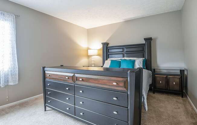 a bedroom with a bed and a dresser