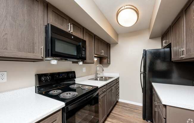 redesigned kitchen with black appliances and white countertops in an apartment