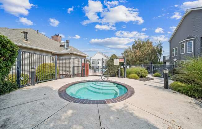 a pool with a fence and houses in the background