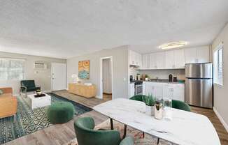 A modern kitchen with a white table and green chairs.