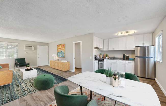 A modern kitchen with a white table and green chairs.