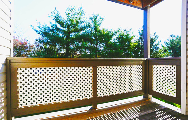 A wooden deck with a lattice design on the railing.