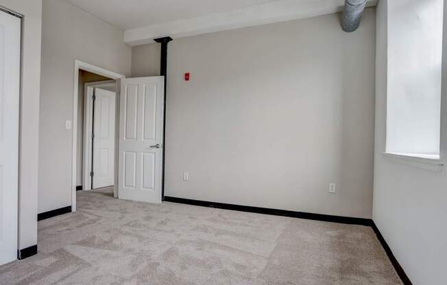 an empty living room with white walls and a door