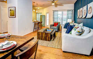 a living room and dining room with a wooden table and chairs at Villa Espada Apartments, San Antonio, 78221