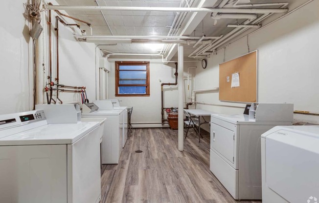 an empty laundry room with washes and dryers in it