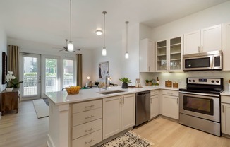 A modern kitchen with a large island and stainless steel appliances.