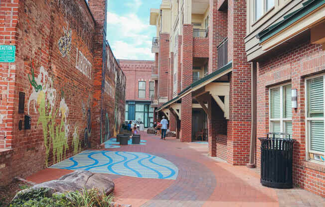 a city street with brick buildings and a blue rug on the sidewalk