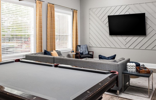 a living room with a ping pong table and a flat screen tv