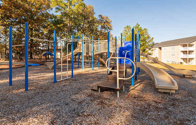 A playground with a slide, swings, and monkey bars.