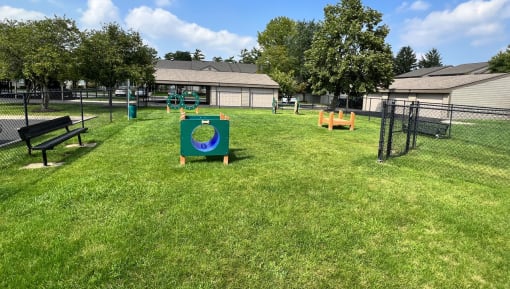 a large grassy area with benches and a sign in the middle of it