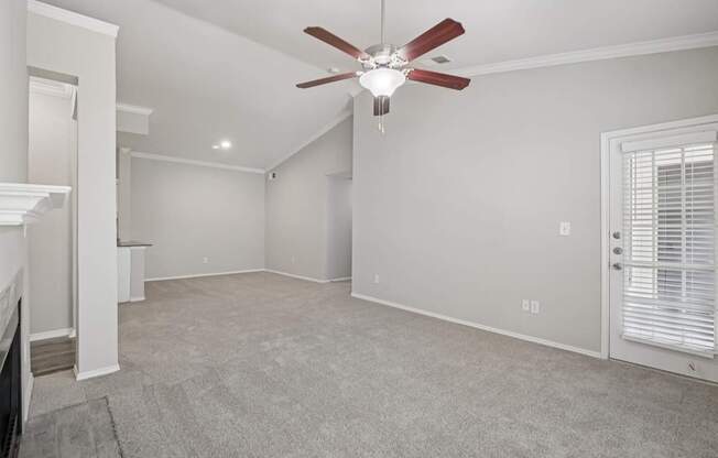 A room with a ceiling fan and carpeted floor.