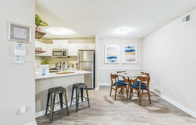 A kitchen with a table and chairs in the middle of the room.