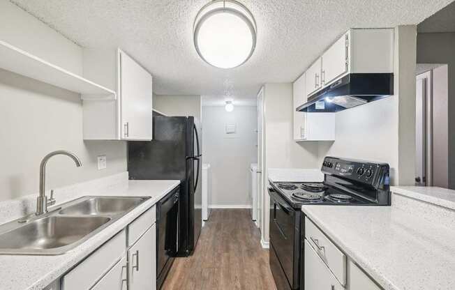 A kitchen with black appliances and white countertops.